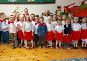 Zdjęcie przedstawia grupę dzieci, które są ubrane w piękne, eleganckie stroje.