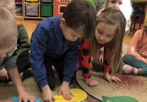 Dzieci na dywanie układają puzzle z serc