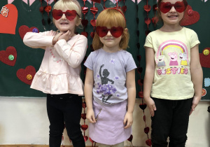 Na zdjęciu widać trzy dziewczynki w czerwonych okularach