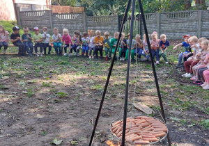 Dzieci siedzą przy ognisku