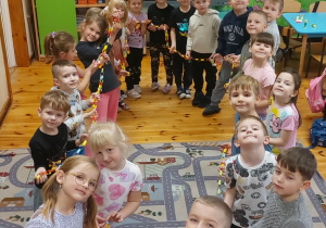 Dzieci stoją w kółku z papierowym łańcuchem