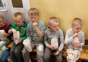Na zdjęciu widać dzieci, które jedzą popcorn.