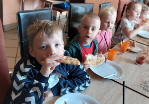 Dzieci częstują się pizzą.