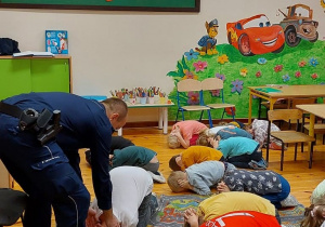 Dzieci wykonują tzw. pozycję „Na żółwia”.
